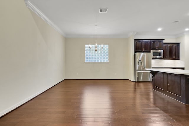 15 Floral Hills Ln, Fulshear, TX 77441 - kitchen featuring stainless steel appliances, a chandelier, crown molding, dark wood finished floors, and light countertops