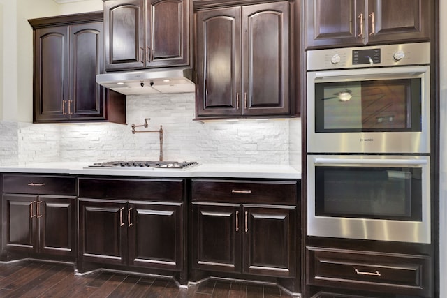 15 Floral Hills Ln, Fulshear, TX 77441 - kitchen featuring appliances with stainless steel finishes, under cabinet range hood, light countertops, and dark wood-type flooring