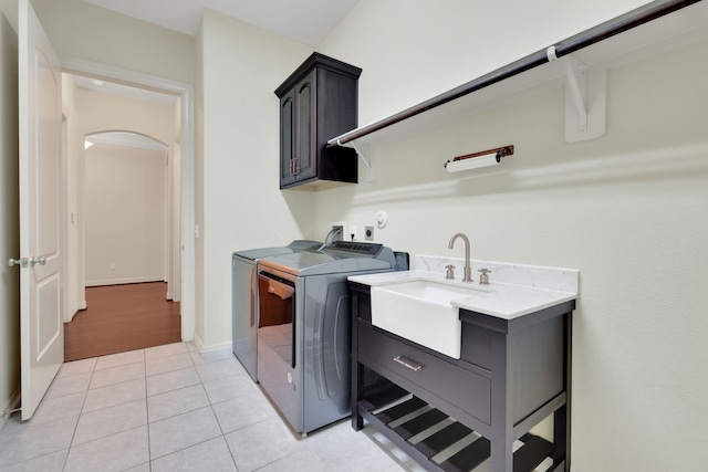 15 Floral Hills Ln, Fulshear, TX 77441 - laundry room featuring cabinet space, washer and dryer, light tile patterned flooring, and arched walkways