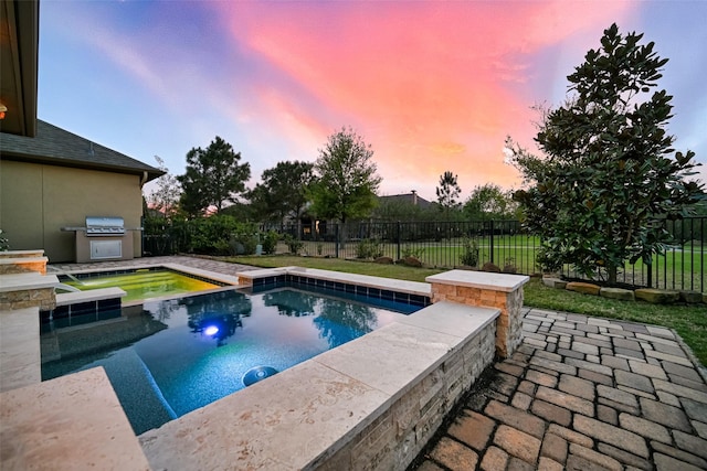 15 Floral Hills Ln, Fulshear, TX 77441 - pool at dusk with an in-ground hot tub, a fenced backyard, and a patio area