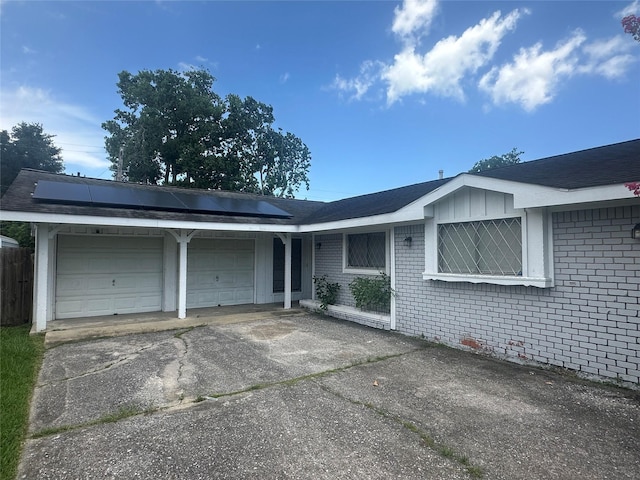 4522 Sage Cir, Baytown, TX 77521 - ranch-style house featuring brick siding, an attached garage, asphalt driveway, and roof mounted solar panels