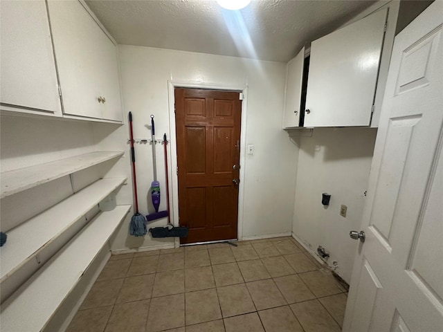 4522 Sage Cir, Baytown, TX 77521 - laundry area with hookup for an electric dryer, cabinet space, light tile patterned floors, and a textured ceiling