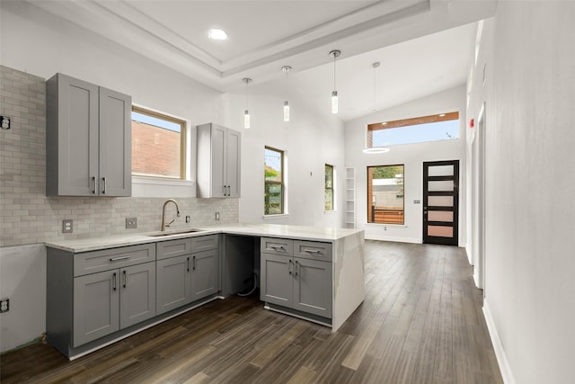 4817 Los Angeles St, Houston, TX 77026 - kitchen featuring gray cabinetry, a peninsula, light countertops, decorative backsplash, and dark wood finished floors
