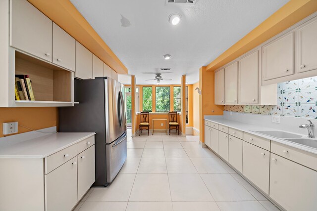 9 Farther Pt, Houston, TX 77024 - kitchen featuring ceiling fan, light countertops, freestanding refrigerator, light tile patterned floors, and white cabinets