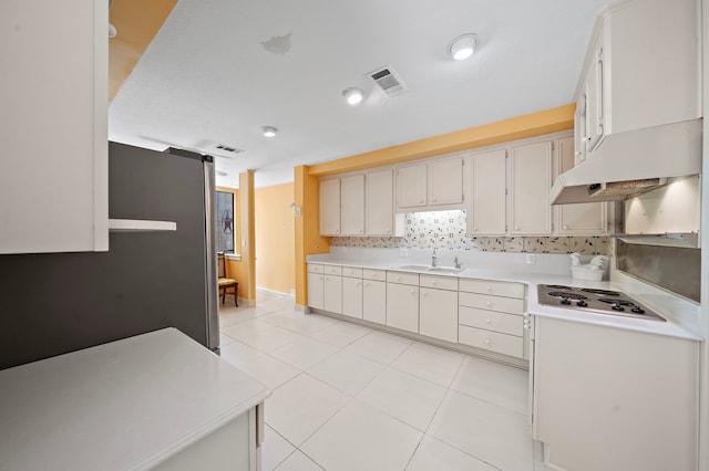9 Farther Pt, Houston, TX 77024 - kitchen featuring electric cooktop, under cabinet range hood, light countertops, decorative backsplash, and light tile patterned flooring
