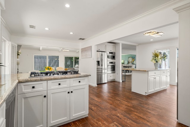 12422 Cobblestone Dr, Houston, TX 77024 - kitchen with stainless steel appliances, ornamental molding, recessed lighting, dark wood-type flooring, and white cabinetry