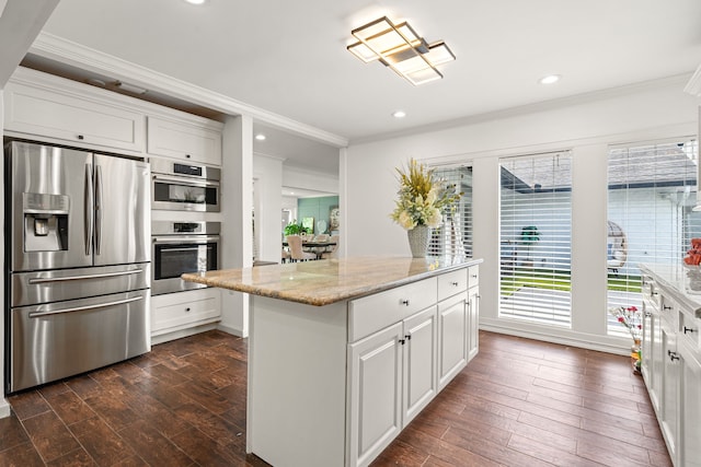12422 Cobblestone Dr, Houston, TX 77024 - kitchen featuring appliances with stainless steel finishes, ornamental molding, dark wood-style flooring, a kitchen island, and white cabinets