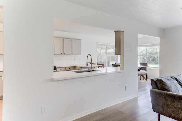 17814 Placid Oak Ct, Cypress, TX 77433 - kitchen with wood finished floors, light countertops, decorative backsplash, and a peninsula