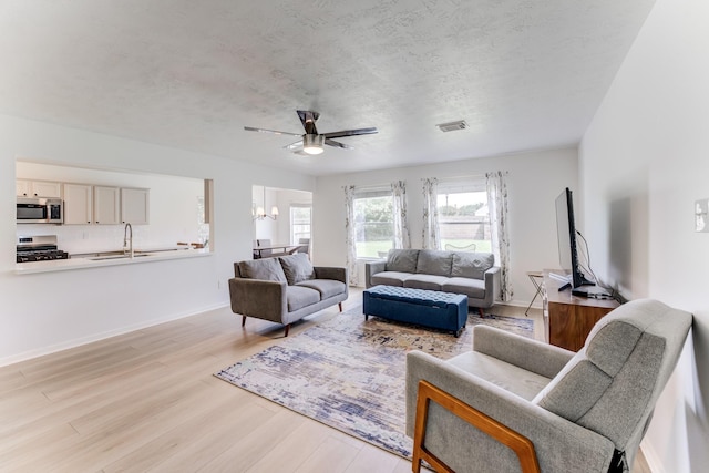 17814 Placid Oak Ct, Cypress, TX 77433 - living room with ceiling fan, light wood-type flooring, and a textured ceiling
