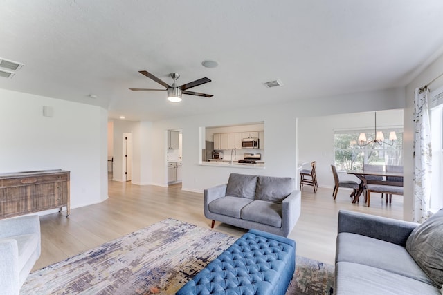 17814 Placid Oak Ct, Cypress, TX 77433 - living area with light wood-type flooring, a chandelier, and ceiling fan