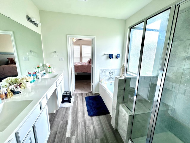 18802 Verdura Dr, New Caney, TX 77357 - ensuite bathroom featuring double vanity, a garden tub, wood finished floors, and a shower stall