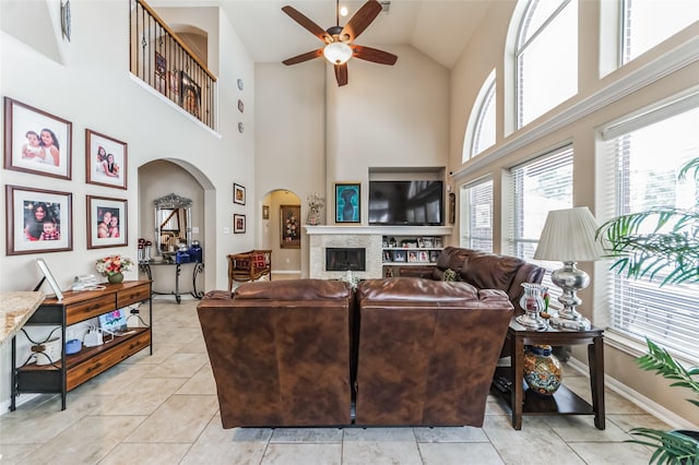 10906 Silverado Trace Dr, Houston, TX 77095 - living room featuring arched walkways, a ceiling fan, high vaulted ceiling, light tile patterned flooring, and a fireplace