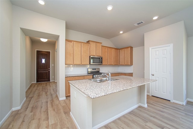 2926 Grand Hawthorne Rd, Conroe, TX 77385 - kitchen featuring appliances with stainless steel finishes, light wood-type flooring, an island with sink, vaulted ceiling, and recessed lighting