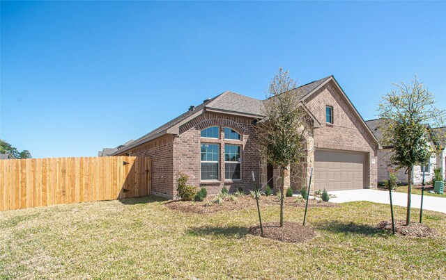 2926 Grand Hawthorne Rd, Conroe, TX 77385 - view of front of property featuring brick siding, driveway, and a shingled roof