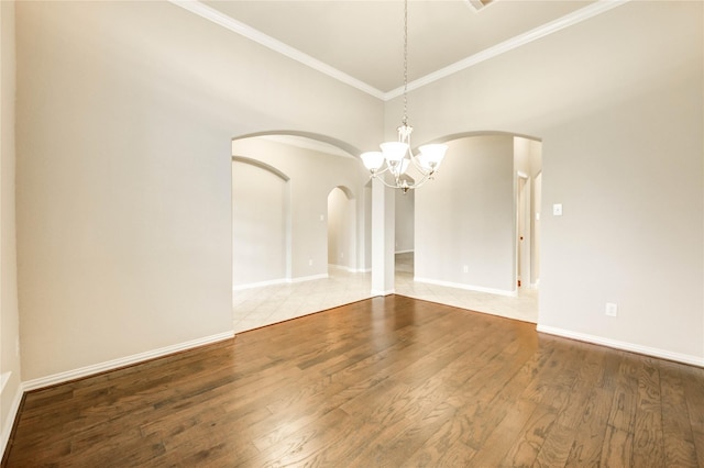 634 Oak Ridge Grove Cir, Spring, TX 77386 - unfurnished room with arched walkways, a chandelier, crown molding, and wood finished floors