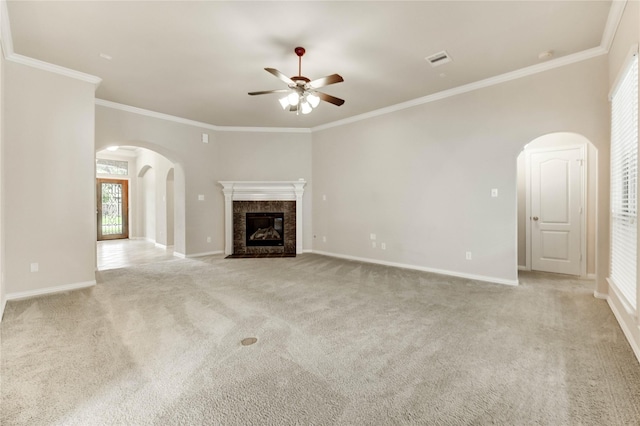 634 Oak Ridge Grove Cir, Spring, TX 77386 - unfurnished living room featuring arched walkways, ceiling fan, crown molding, light colored carpet, and healthy amount of natural light