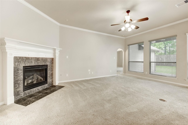 634 Oak Ridge Grove Cir, Spring, TX 77386 - unfurnished living room with carpet, a ceiling fan, crown molding, a tiled fireplace, and arched walkways