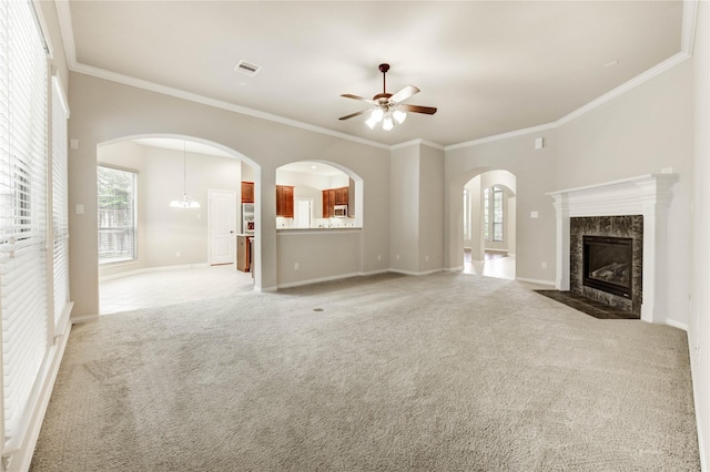 634 Oak Ridge Grove Cir, Spring, TX 77386 - unfurnished living room featuring a ceiling fan, a premium fireplace, light carpet, ornamental molding, and arched walkways