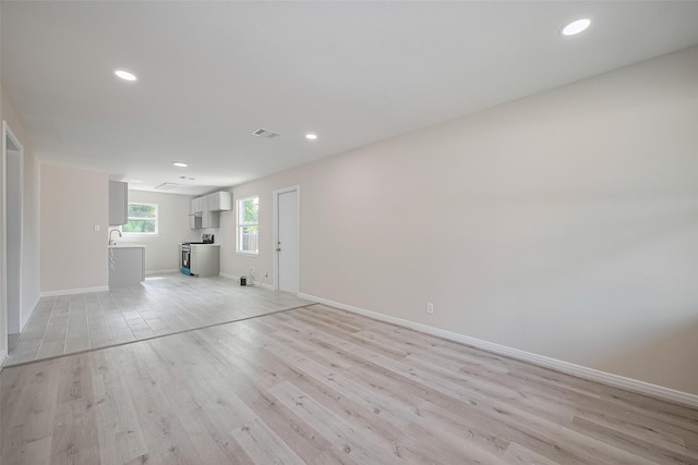 11311 Raincove Dr, Houston, TX 77016 - unfurnished living room with light wood finished floors and recessed lighting