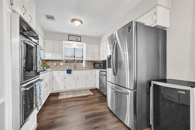 2703 Shady Creek Dr, Pearland, TX 77581 - kitchen with stainless steel appliances, wine cooler, white cabinetry, backsplash, and dark wood-type flooring