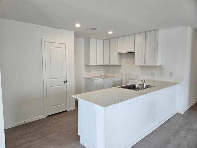402 Emma St, Angleton, TX 77515 - kitchen with wood finished floors, white cabinetry, a peninsula, and recessed lighting