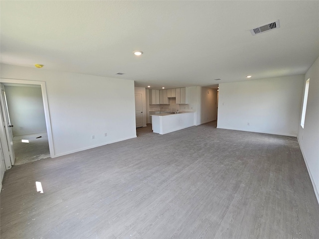 402 Emma St, Angleton, TX 77515 - unfurnished living room with light wood-type flooring and recessed lighting