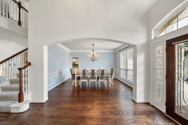18806 Manleigh Ct, Tomball, TX 77377 - foyer entrance with a chandelier, arched walkways, crown molding, stairway, and dark wood-style flooring