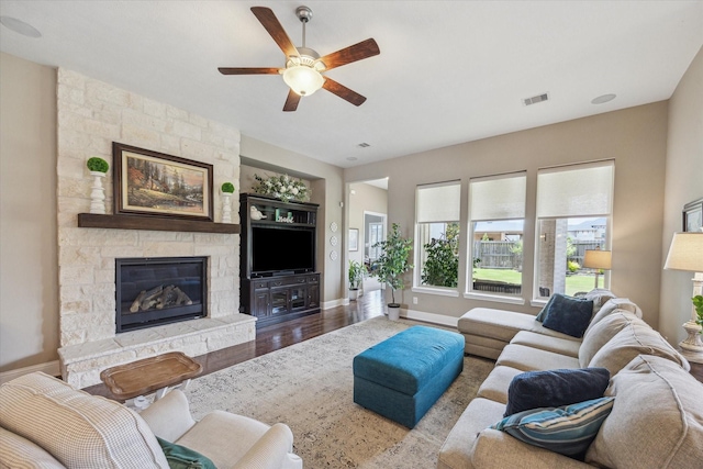 28114 Bayou Cove Ct, Fulshear, TX 77441 - living room with a ceiling fan, wood finished floors, and a stone fireplace