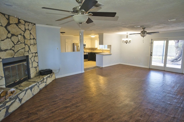 1303 Mac Dr, Sweeny, TX 77480 - unfurnished living room with ceiling fan, a textured ceiling, ornamental molding, wood finished floors, and a stone fireplace