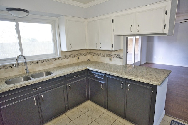 1303 Mac Dr, Sweeny, TX 77480 - kitchen featuring white cabinets, ornamental molding, decorative backsplash, a peninsula, and light stone countertops