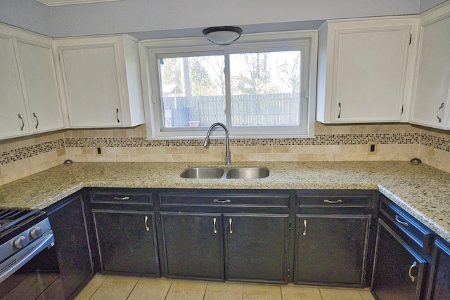 1303 Mac Dr, Sweeny, TX 77480 - kitchen with stainless steel range with gas cooktop, white cabinetry, decorative backsplash, light tile patterned floors, and light stone countertops