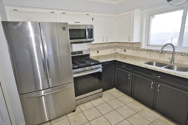 1303 Mac Dr, Sweeny, TX 77480 - kitchen featuring appliances with stainless steel finishes, white cabinetry, light tile patterned floors, dark cabinetry, and light stone counters