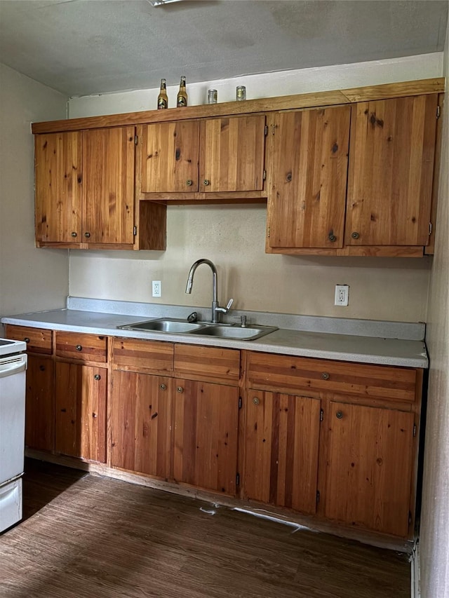 1206 11th St N, Texas City, TX 77590 - kitchen with brown cabinetry, light countertops, stove, and dark wood finished floors