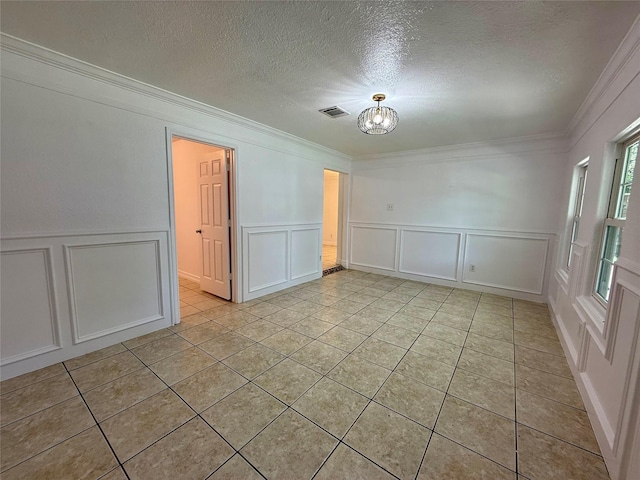 5701 Luna St, Houston, TX 77076 - spare room featuring a decorative wall, crown molding, light tile patterned floors, and a textured ceiling