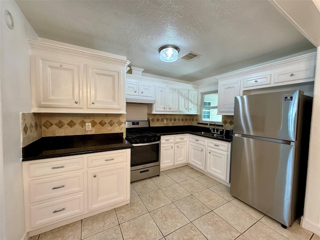 5701 Luna St, Houston, TX 77076 - kitchen with stainless steel appliances, under cabinet range hood, dark countertops, light tile patterned flooring, and decorative backsplash