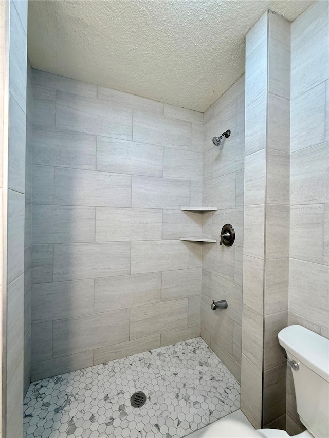 5701 Luna St, Houston, TX 77076 - bathroom with a tile shower and a textured ceiling