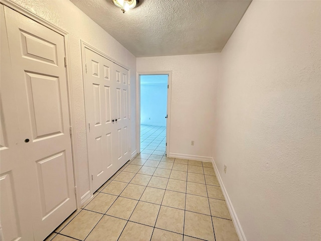 5701 Luna St, Houston, TX 77076 - hallway featuring a textured ceiling, light tile patterned flooring, and a textured wall