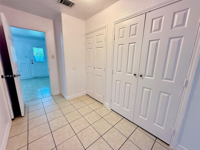 5701 Luna St, Houston, TX 77076 - corridor featuring light tile patterned flooring and a textured ceiling