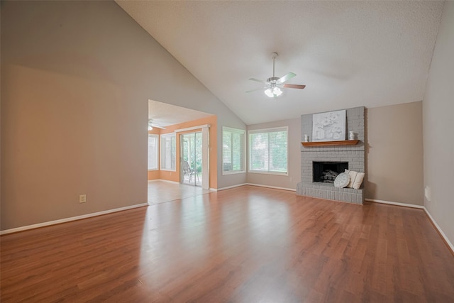 3031 The Highlands Dr, Sugar Land, TX 77478 - unfurnished living room with a ceiling fan, wood finished floors, a brick fireplace, and high vaulted ceiling