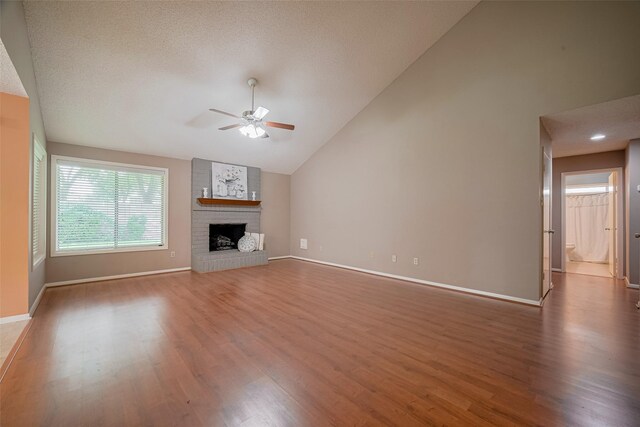 3031 The Highlands Dr, Sugar Land, TX 77478 - unfurnished living room with ceiling fan, wood finished floors, vaulted ceiling, and a fireplace