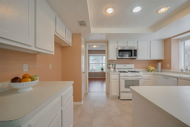3031 The Highlands Dr, Sugar Land, TX 77478 - kitchen featuring white appliances, light countertops, a raised ceiling, recessed lighting, and light tile patterned flooring