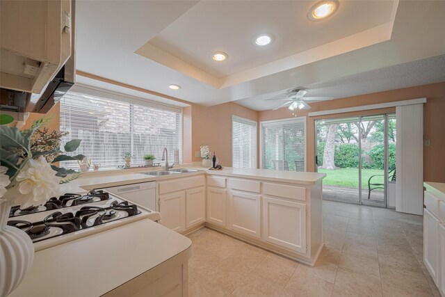 3031 The Highlands Dr, Sugar Land, TX 77478 - kitchen with a peninsula, a raised ceiling, light countertops, recessed lighting, and a ceiling fan