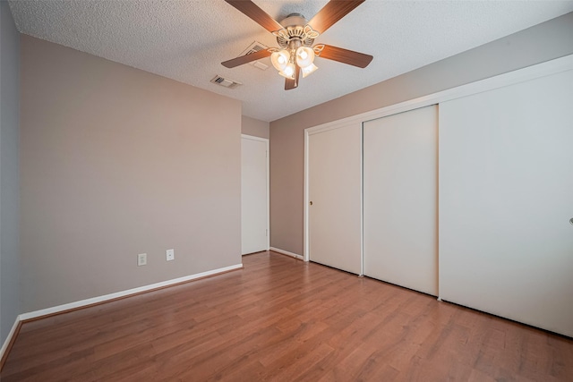3031 The Highlands Dr, Sugar Land, TX 77478 - unfurnished bedroom with wood finished floors, a closet, ceiling fan, and a textured ceiling