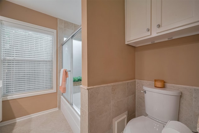 3031 The Highlands Dr, Sugar Land, TX 77478 - full bath featuring tile walls, a wainscoted wall, tile patterned flooring, and shower / bath combination with glass door