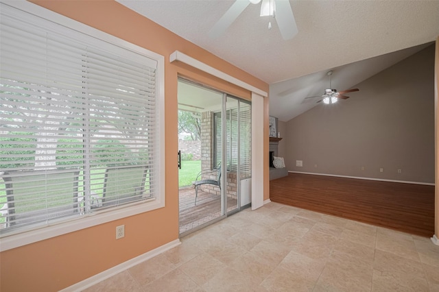3031 The Highlands Dr, Sugar Land, TX 77478 - empty room with ceiling fan, vaulted ceiling, a fireplace, and light tile patterned flooring