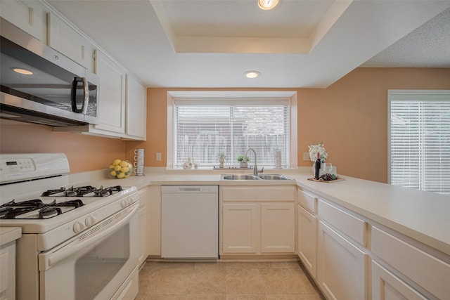 3031 The Highlands Dr, Sugar Land, TX 77478 - kitchen featuring white appliances, light countertops, light tile patterned floors, a raised ceiling, and recessed lighting