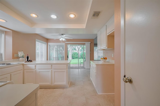 3031 The Highlands Dr, Sugar Land, TX 77478 - kitchen featuring a tray ceiling, recessed lighting, ceiling fan, light countertops, and white cabinetry