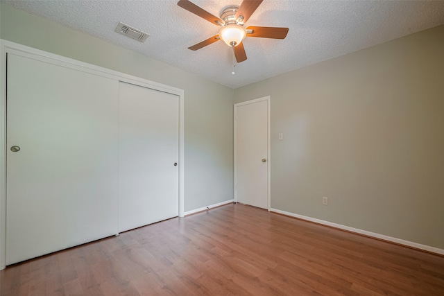 3031 The Highlands Dr, Sugar Land, TX 77478 - unfurnished bedroom featuring wood finished floors, a closet, a textured ceiling, and a ceiling fan