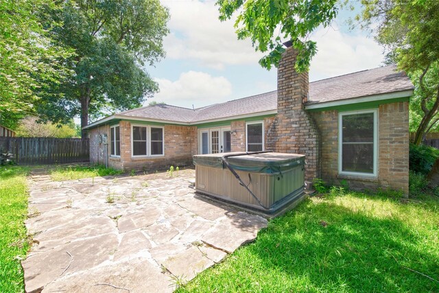 25418 Sugar Valley Ln, Spring, TX 77373 - rear view of property featuring a hot tub, a patio area, a fenced backyard, a chimney, and roof with shingles