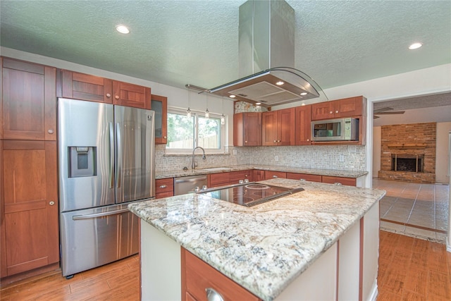 25418 Sugar Valley Ln, Spring, TX 77373 - kitchen with stainless steel appliances, island range hood, a textured ceiling, decorative backsplash, and light wood finished floors